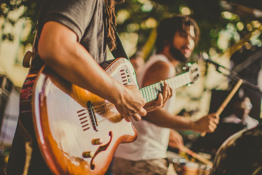 Dynamic image of a band playing live music, featuring guitar and drums.
